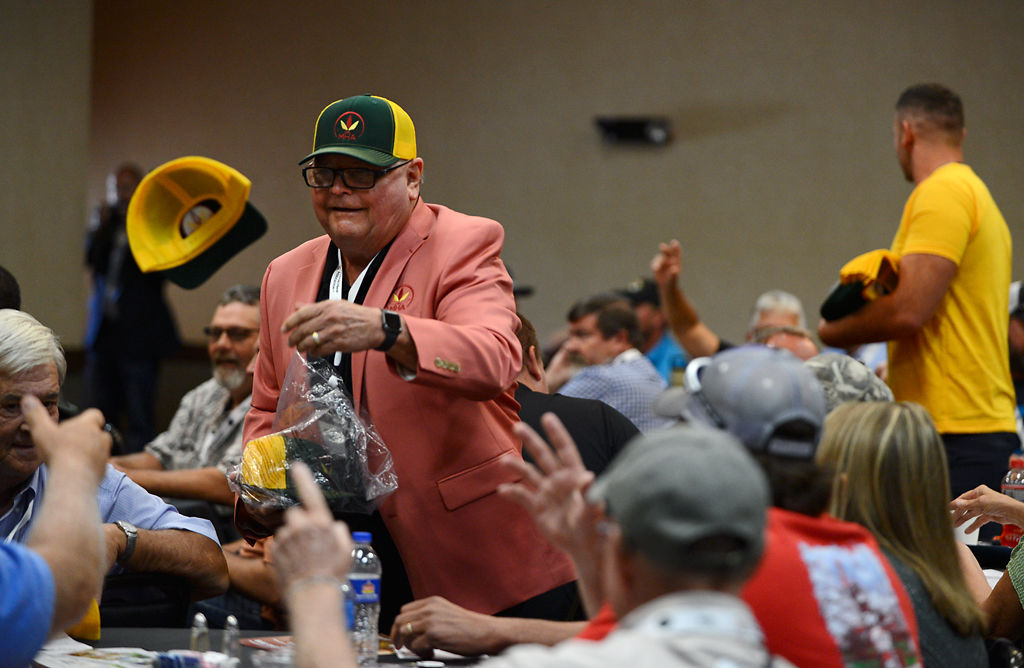 Bill Cook tosses hats to members